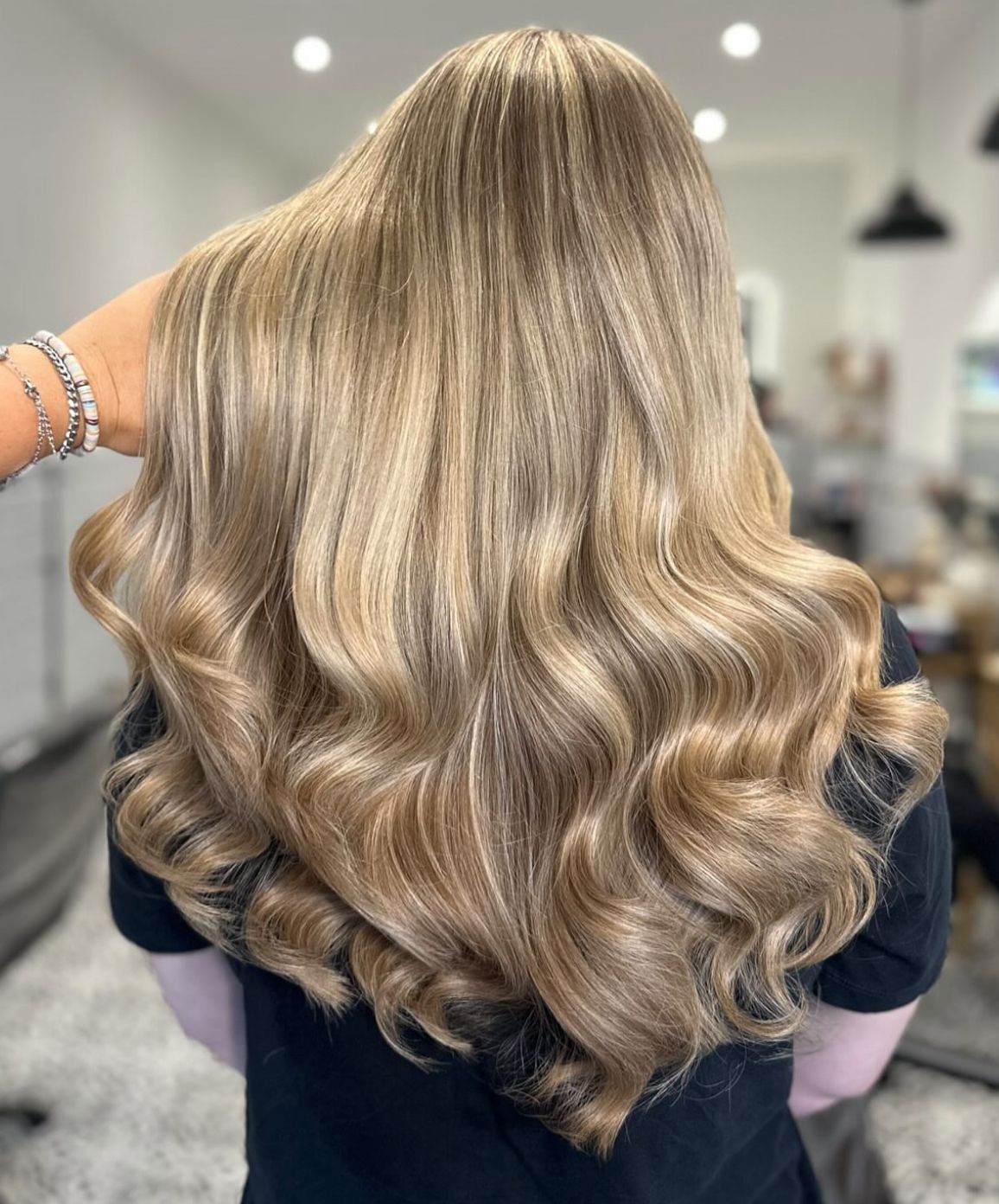 Long blonde balayage with soft waves, finished at Mane London